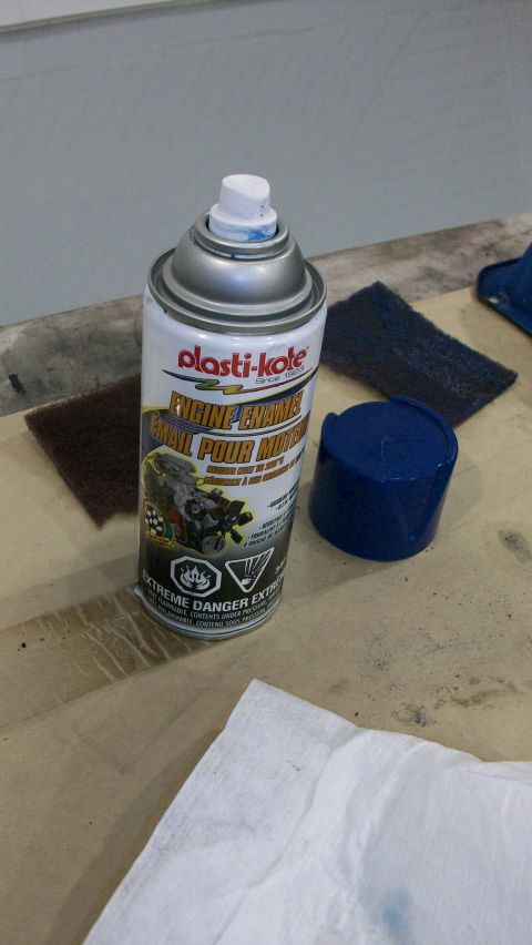 1973 Ford Ranchero - A can of Plasti-Kote Engine Enamel sits on a wooden surface with a blue cap and abrasive pads nearby.