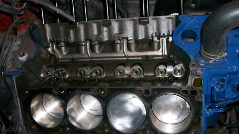 1973 Ford Ranchero - Close-up view of an engine block, showing pistons, valve train components, and a blue painted section with a hose attached.