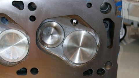 1973 Ford Ranchero - Engine cylinder head with intake and exhaust valve seats visible, plus a spark plug hole.