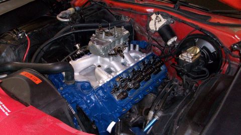 1973 Ford Ranchero - Close-up of a blue Ford V8 engine with a carburetor and various engine components visible.