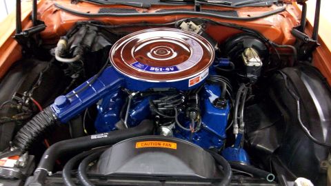 1973 Ford Ranchero - Engine bay of a 1973 Ford Ranchero a blue 351-4V engine with a chrome air cleaner and "Caution Fan" label.