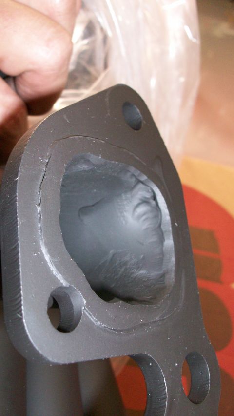 1973 Ford Ranchero - Close-up of an exhaust manifold port, showing the rough internal casting. The Supermotors.net logo is visible in the lower right corner.