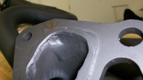 1973 Ford Ranchero - A close-up view of a metal engine part, showing machining marks and orange paint markings.