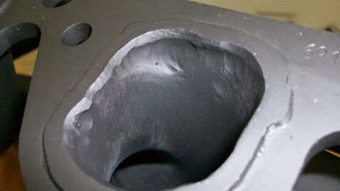 1973 Ford Ranchero - Engine exhaust manifold port showing internal casting marks and an exterior part number.