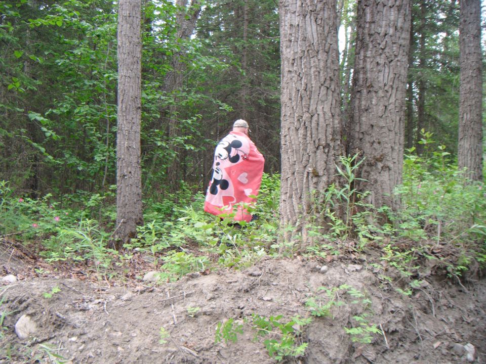 Person in Mickey Mouse blanket in woods, Supermotors logo at bottom right