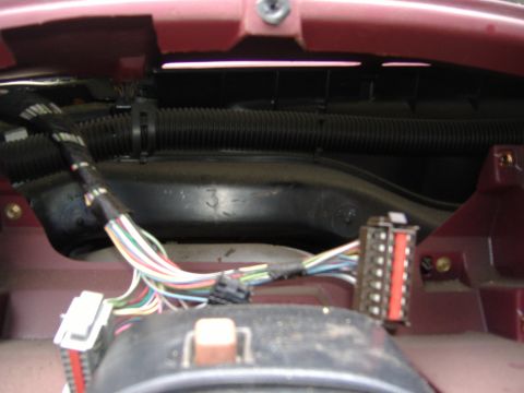 1995 Ford F-150 - Interior view of a vehicle's dashboard reveals a tangled wiring harness and various electrical connectors.