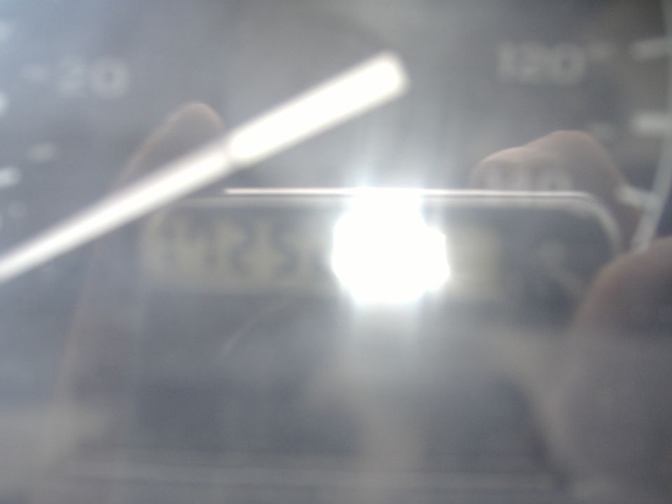 Dashboard gauge cluster with bright reflection obscuring numbers
