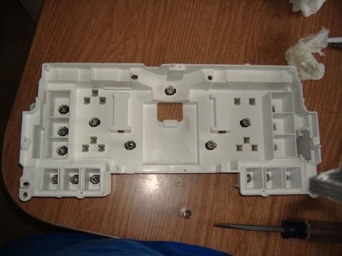 1995 Ford F-150 - The interior of a vehicle's instrument cluster housing is shown, with various mounting points and electrical connection sockets visible.