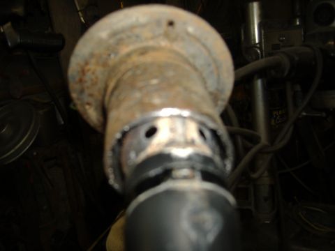 1995 Ford F-150 - Close-up of a rusted metal pipe fitting with visible holes and a black rubber seal.