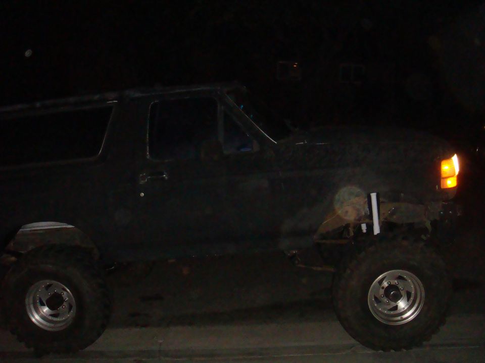 Side view of a black 1992 Ford Bronco with lifted suspension and large tires