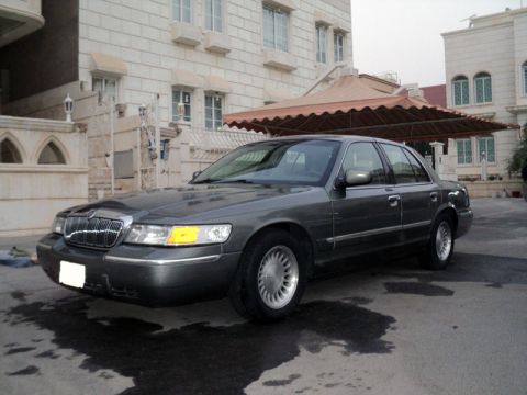 2001 Mercury Grand Marquis - Dark gray 2001 Mercury Grand Marquis sedan parked outside a building.