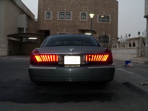 2001 Mercury Grand Marquis - The rear of a 2001 Mercury Grand Marquis is shown with its distinctive vertical taillights illuminated.