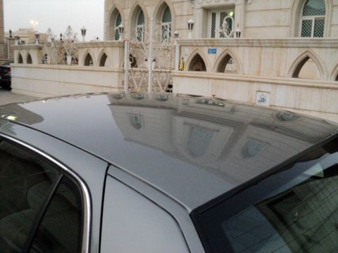2001 Mercury Grand Marquis - Car roof shows reflection of a building with arched windows and decorative fencing.