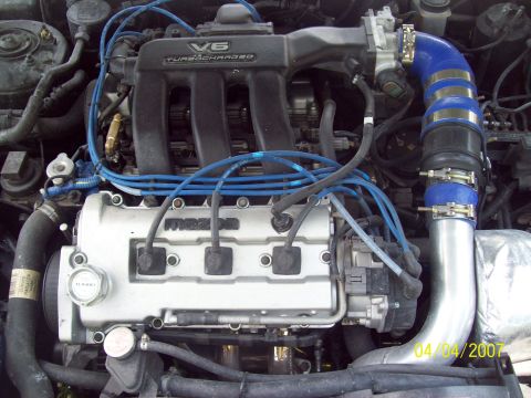 1995 Ford Probe - Close-up view of a turbocharged V6 engine, identified by the 'Mazda' branding on the valve cover.