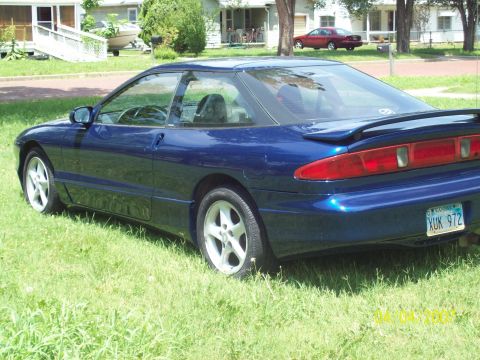 1995 Ford Probe - A blue 1995 Ford Probe is parked on a grassy lawn in front of a house.