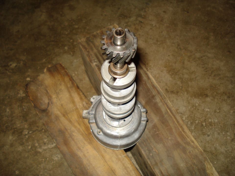 Distributor with a gear on top, resting on wood planks