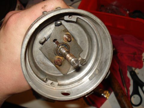 1967 Ford F-250 - A hand holds a disassembled distributor cap, revealing its internal components and signs of age.