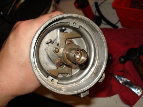 1967 Ford F-250 - A close-up view of a vehicle's distributor part, held by a hand, with some internal components visible.