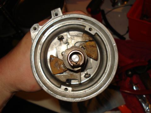 1967 Ford F-250 - The inside of a vehicle's distributor cap shows worn contact points and some rust.