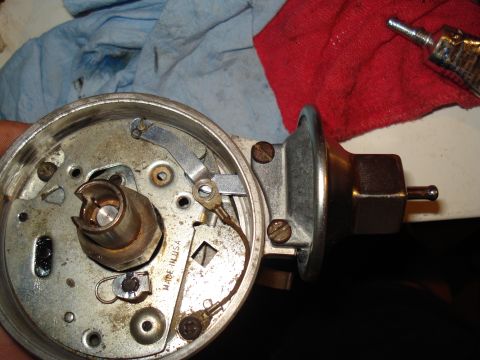 1967 Ford F-250 - This photo shows a disassembled automotive distributor, a component of the ignition system, with visible internal workings and external par…