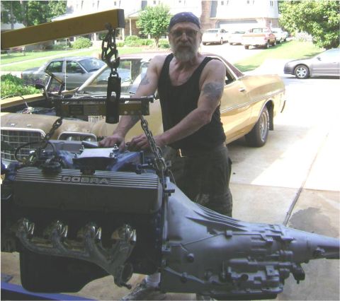1972 Ford Ranchero - Man removes engine from a gold 1970 Ford Ranchero using an engine hoist.