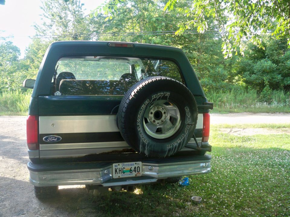 Rear view of a dark green 1992 Ford Bronco with a spare tire mounted on the back