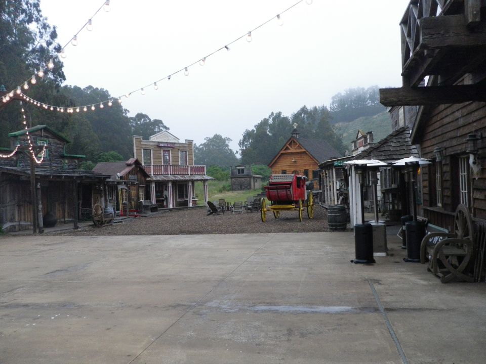 Western town scene with a red carriage and wooden buildings