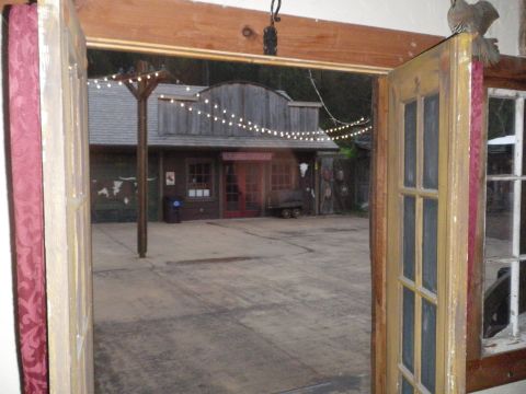 1991 Ford Bronco - A rustic building with a western facade is illuminated by decorative string lights, viewed from an interior space.
