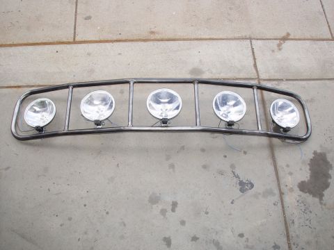 1993 Ford Bronco - A custom metal light bar with five spotlights is shown resting on a concrete surface.