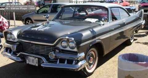 1991 Ford Crown Victoria - A 1957 Dodge Custom Royal is displayed at a car show, its distinctive fins and chrome grille.