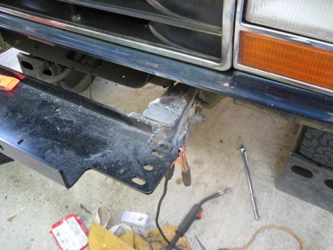1991 Ford Explorer - Repairing a bumper bracket with welding equipment and tools nearby.