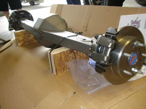 1990 Ford Bronco - Rear axle assembly with disc brakes and a blue center cap is displayed on cardboard.