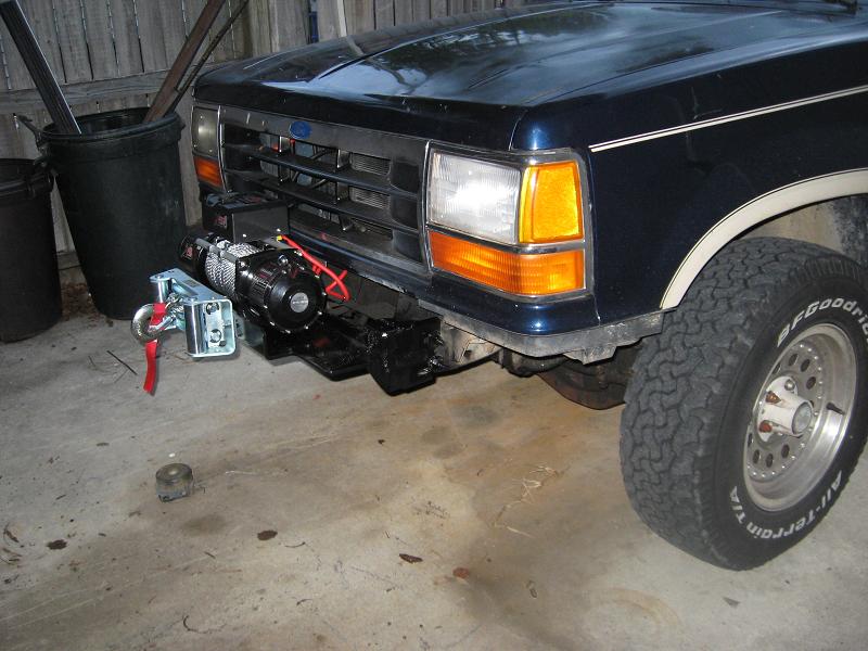 Dark blue Ford SUV in garage with front winch on exposed bumper mount and BFG All-Terrain tires
