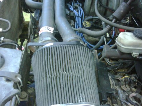1991 Ford Bronco - Close-up of the engine bay of a 1991 Ford Bronco, highlighting the air filter and associated engine components.