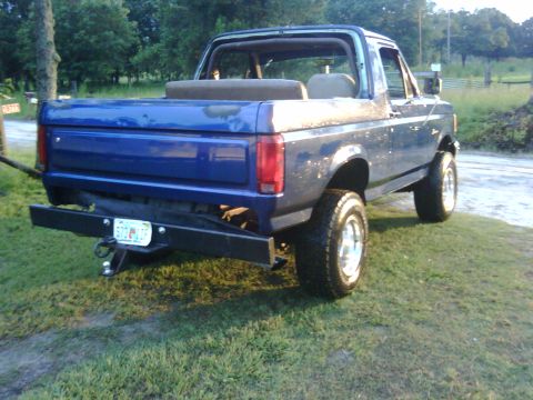 1991 Ford Bronco - Rear view of a blue 1991 Ford Bronco with an aftermarket bumper and visible license plate.