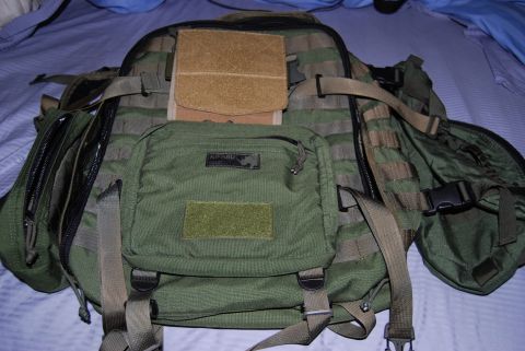 1991 Ford Bronco - A green tactical backpack with multiple compartments and straps is shown laid out on a blue surface.