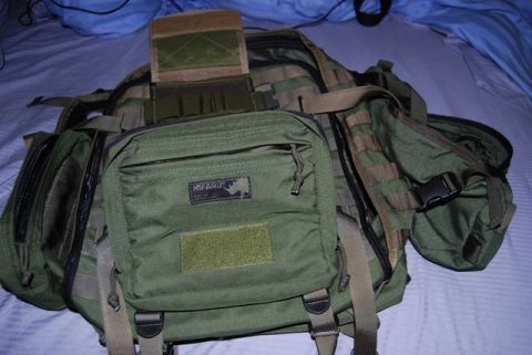 1991 Ford Bronco - A green tactical backpack with various compartments and MOLLE webbing is displayed on a bed.