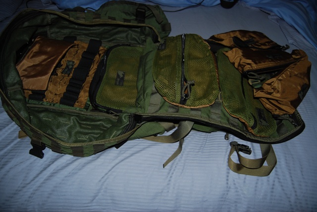 Open green and tan tactical backpack with multiple compartments and mesh pockets