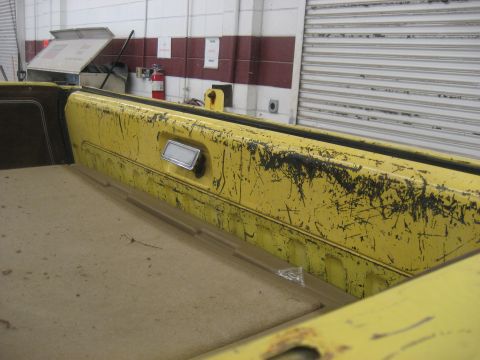 1978 Ford Bronco - Close-up of a worn yellow interior panel with a chrome handle.