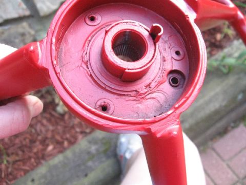 1966 Ford F-100 - Close-up of a red steering wheel hub, showing the central splined shaft and mounting holes.