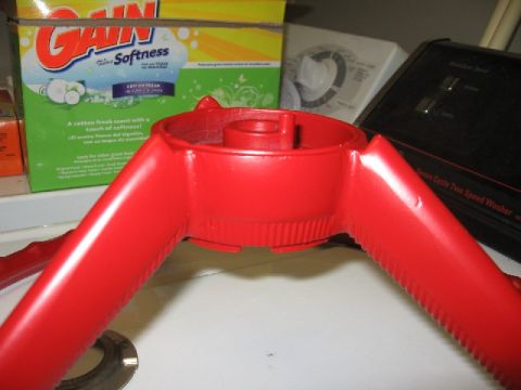 1966 Ford F-100 - A red steering wheel component is shown in close-up, with household items in the background.