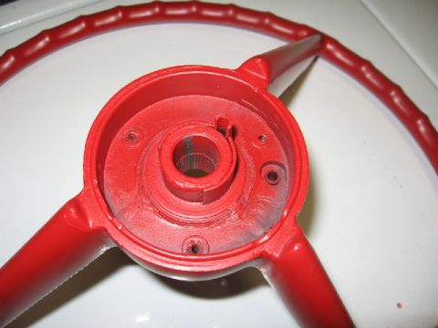 1966 Ford F-100 - Close-up view of a red steering wheel component, likely for restoration or repair.