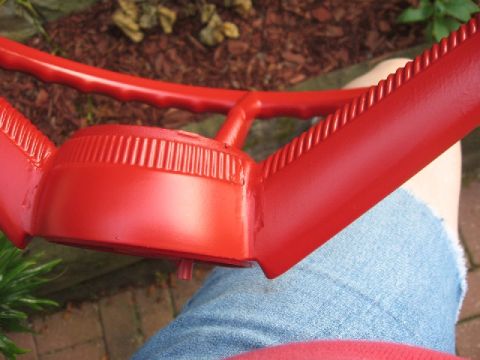 1966 Ford F-100 - A red steering wheel, likely undergoing restoration, is shown close-up with a person's leg in the background.