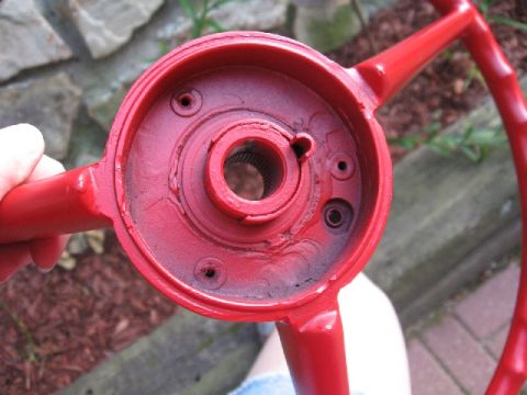 1966 Ford F-100 - A red steering wheel hub is held up, showing the splined shaft connection point.