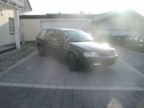 2003 Audi A6 - A dark colored Audi A6 Avant is parked in a paved driveway in front of a house and garage.