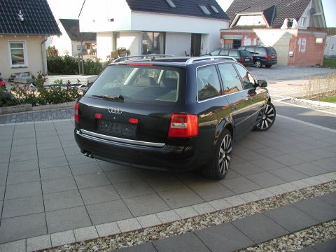 2003 Audi A6 - This black Audi A6 wagon is seen from the rear, parked on a paved driveway with a modern house in the background.