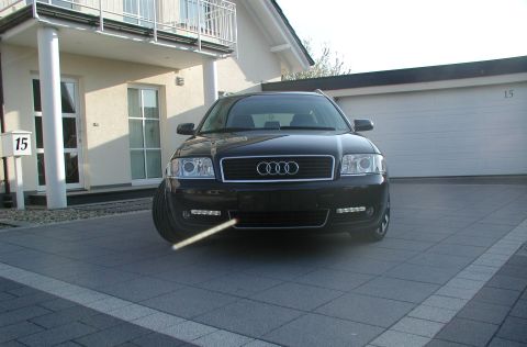 2003 Audi A6 - The front of a black Audi A6 is shown parked in a paved driveway, with a house and garage in the background.