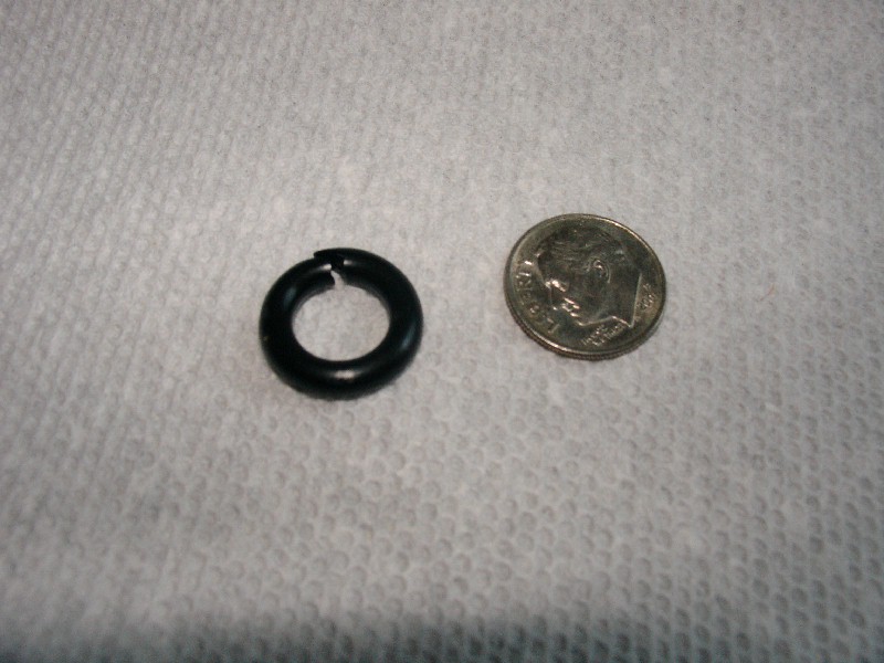 Black o-ring next to a dime