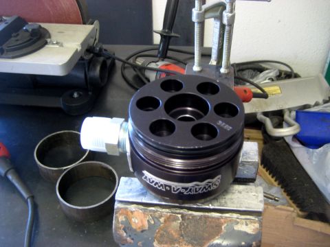 1996 Ford Bronco - A 'SWAY-A-WAY' hydraulic pump part is clamped in a vise, with shop tools in the background.