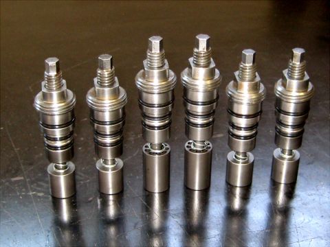 1996 Ford Bronco - Close-up view of several metallic shock absorber components, each with distinct rings and a hexagonal top.